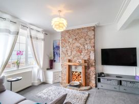 A living room with a stone fireplace and television at 45 North View in Brixham