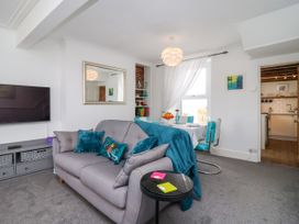 A living room with a sofa and dining table at 45 North View Brixham