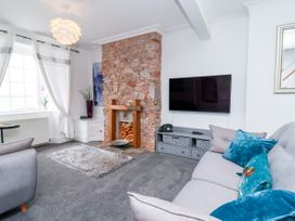 A living room with a stone fireplace and television at 45 North View in Brixham