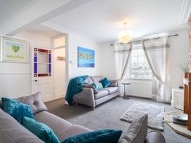 A living room with a sofa and wall art at 45 North View in Brixham