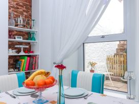 A dining table with fruit and a window overlooking a patio at 45 North View Brixham
