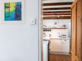 A kitchen with white cabinets and a door at 45 North View Brixham