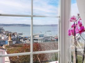 A view of boats on water from a window with an orchid at 45 North View in Brixham