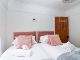 A bedroom with twin beds and a wooden door at 45 North View Brixham