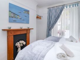 A bedroom with two beds and a painting at 45 North View in Brixham
