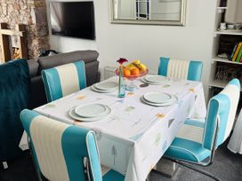 A dining room with a table set and a television at 45 North View in Brixham