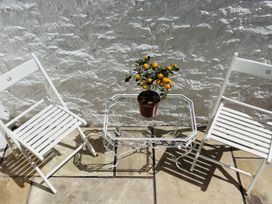 Two white chairs and a table with a potted orange tree at 45 North View Brixham