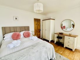 A bedroom with a bed and wardrobe at Lizzy’s Cottage in Brixham