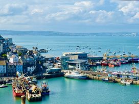 A harbor with fishing boats and buildings near the water at Lizzy’s Cottage in Brixham