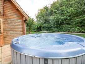 A hot tub beside a wooden cabin at Pen Y Clawdd Beggar's Bush near Presteigne