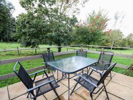 An outdoor seating area with a table and chairs at Pen Y Clawdd near Beggar's Bush