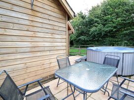 An outdoor area with a table and chairs beside a hot tub at Pen Y Clawdd Beggar's Bush near Presteigne