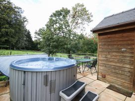 An outdoor area with a hot tub and seating at Pen Y Clawdd Beggar's Bush near Presteigne