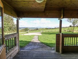 View from a wooden porch overlooking grassy fields and hills at Pen Y Clawdd Beggar's Bush near Presteigne