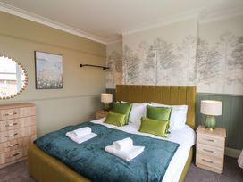 A bedroom with a bed and bedside tables at Crescent Bay House