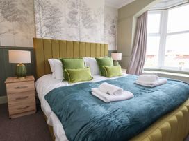 A bedroom with a bed and bedside lamp at Crescent Bay House