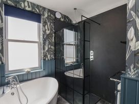 A bathroom with a bathtub and shower at Crescent Bay House