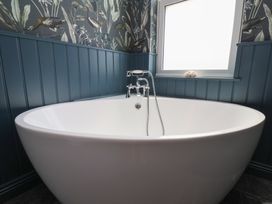 A bathtub with a faucet and window in a bathroom at Crescent Bay House
