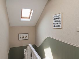 A staircase with a skylight and wall decor at Crescent Bay House