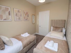 A bedroom with twin beds and wall art at Crescent Bay House