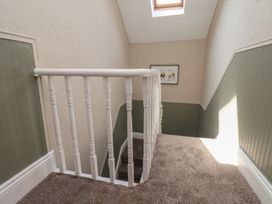 A staircase with a handrail and artwork on the wall at Crescent Bay House