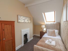 A bedroom with a single bed and wardrobe at Crescent Bay House