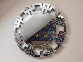 A decorative round mirror with a patterned background at Crescent Bay House 