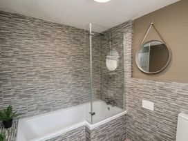 A bathroom with a bathtub and shower at Crescent Bay House