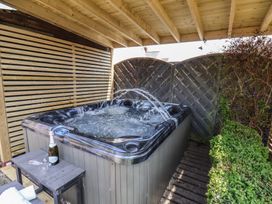A hot tub with a table and champagne at Crescent Bay House