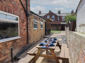 A dining setup with table and plates in a backyard at Crescent Bay House