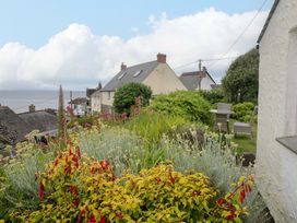 A garden with flowers and houses by the sea at Mermaid Cottage in Coverack near St Keverne