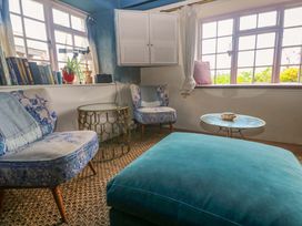 A living room with armchairs and a table at Mermaid Cottage in Coverack near St Keverne