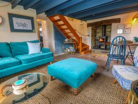 A living room with a sofa and fireplace at Mermaid Cottage near Coverack near St Keverne