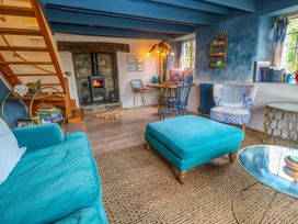 A living room with a fireplace and seating arrangements at Mermaid Cottage in Coverack near St Keverne