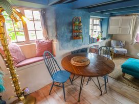 A dining room with a wooden table and chairs at Mermaid Cottage Coverack near St Keverne