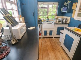 A kitchen with a sink and appliances at Mermaid Cottage in Coverack near St Keverne