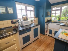 A kitchen featuring a sink, oven, microwave, and countertop at Mermaid Cottage Coverack near St Keverne