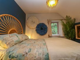 A bedroom with a bed and decorative wall art at Mermaid Cottage in Coverack near St Keverne