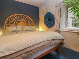 A bedroom with a bed and decorative wall art at Mermaid Cottage in Coverack near St Keverne