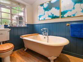 A bathroom with a bathtub and toilet at Mermaid Cottage in Coverack near St Keverne