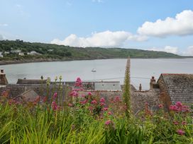 A view of a bay with flowers and houses at Mermaid Cottage in Coverack near St Keverne