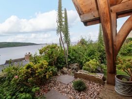 A garden with plants and a river view at Mermaid Cottage in Coverack near St Keverne