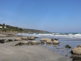 A beach with rocks and waves at Mermaid Cottage in Coverack near St Keverne