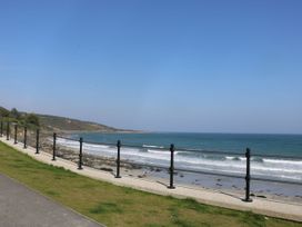 An ocean view with waves and a fence at Mermaid Cottage in Coverack near St Keverne