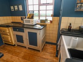 A kitchen with an oven, microwave, and sink at Mermaid Cottage in Coverack near St Keverne