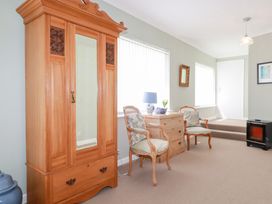 A living room with a wardrobe and chairs at 22 Pentire Avenue Newquay