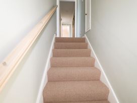 A staircase with carpet and a handrail at 22 Pentire Avenue in Newquay
