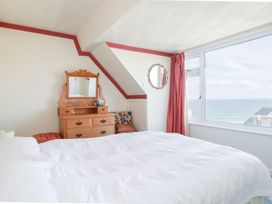 A bedroom with a bed and dresser at 22 Pentire Avenue Newquay