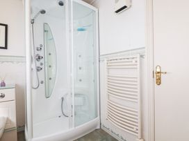 A bathroom with a shower and radiator at 22 Pentire Avenue in Newquay