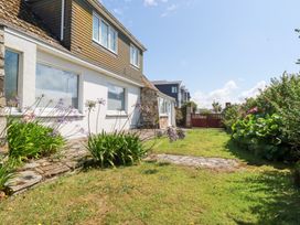 A garden area with flowers and a house at 22 Pentire Avenue Newquay